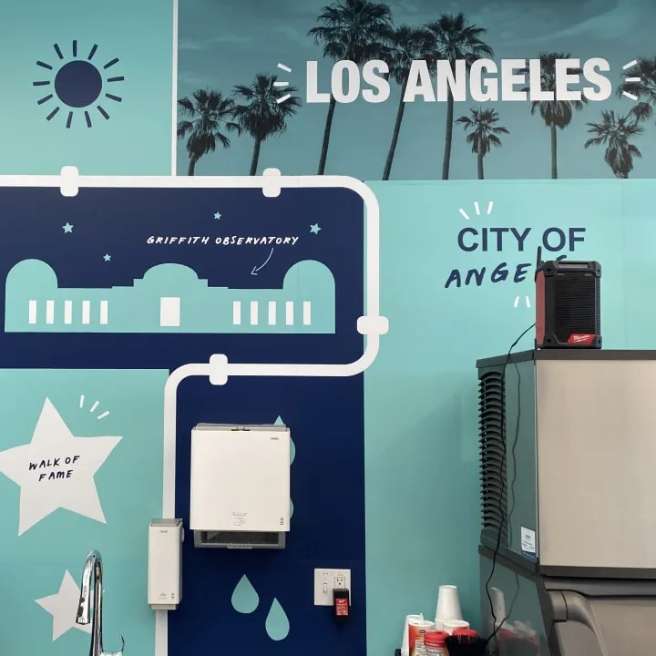 A teal wall mural in a Reece branch reading “Los Angeles” and “City of Angels”, with palm trees and the Griffith Observatory