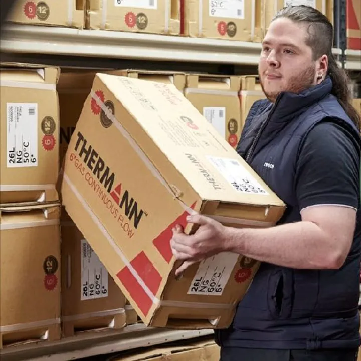 A warehouse worker lifting a Thermann “6 Star continuous flow” box from stacked shelves