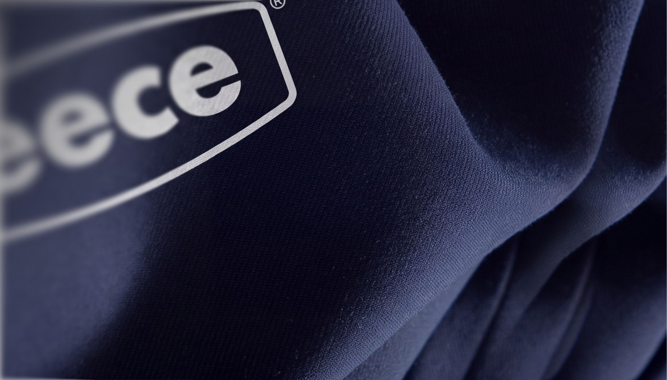 A close-up of a navy Reece t-shirt, its white Reece logo softly blurred
