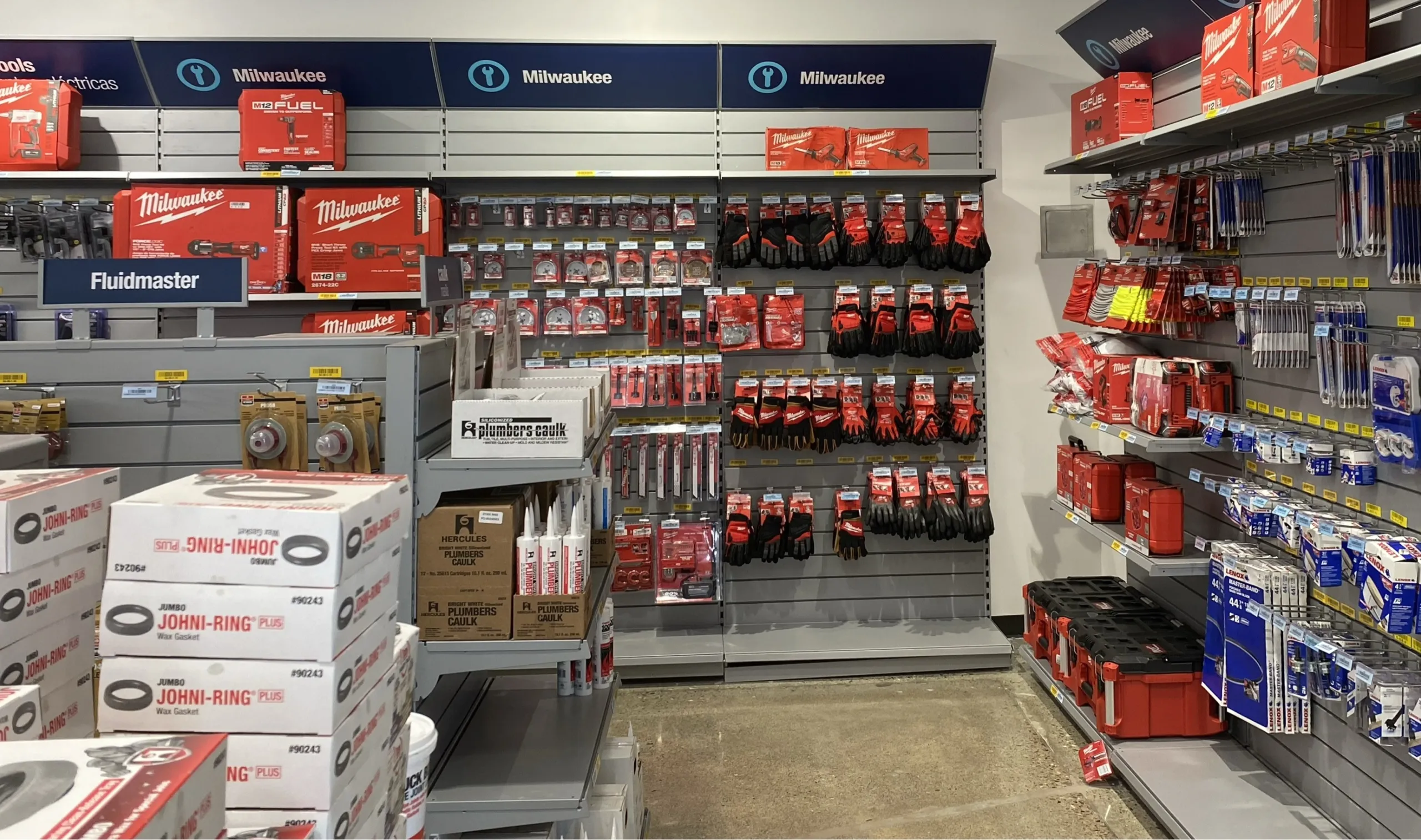A Reece branch’s power tool aisle, with walls of red Milwaukee tools and accessories under navy Milwaukee signs