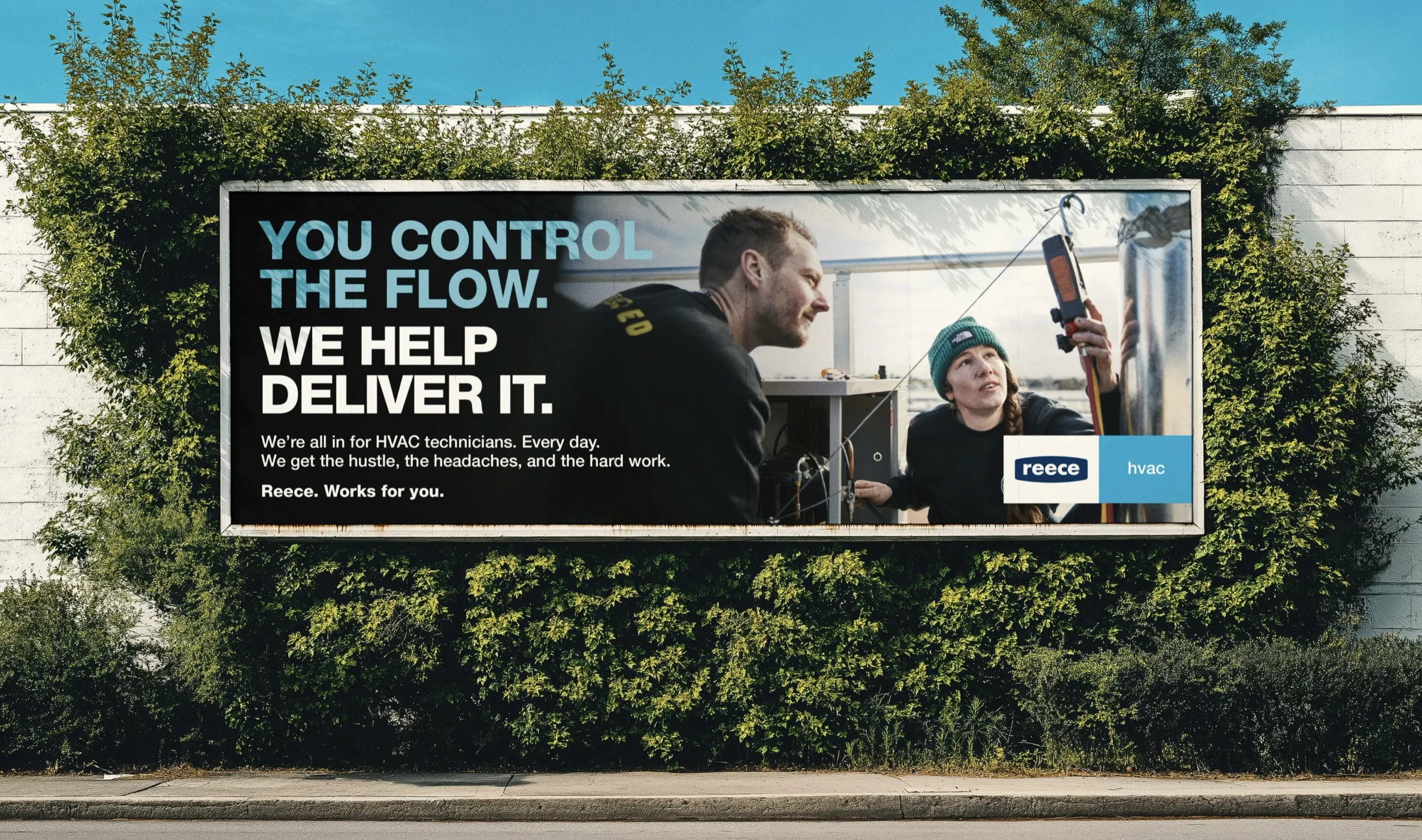 A Reece HVAC billboard set into a hedge, reading “You control the flow. We help deliver it. We’re all in for HVAC technicians. Every day. We get the hustle, the headaches, and the hard work. Reece. Works for you.”